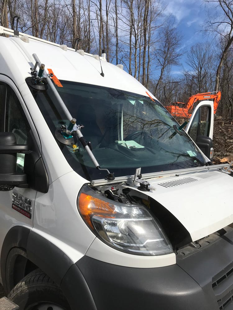 A white van with a newly installed windshield by Tri County Glass & Doors Inc.